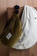Bum Bag pattern – two bags hanging wood background, corduroy khaki and canvas off-white, navy handle – Atelier Brunette
