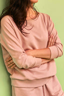 Patron Le Sweat – Plan buste, sweat rose poudré bras croisés, manches 3/4 bord-côte, fond vert sauge – Atelier Brunette