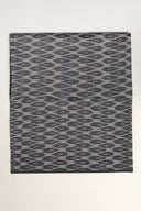 L'Ikat fabric in anthracite folded flat, with a wavy ikat-style pattern visible across the whole piece.