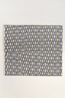 L'Ikat fabric in off-white folded flat, with a wavy blue and anthracite ikat-style stripe pattern visible across the whole piece.