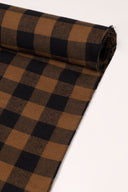 Close-up of the corner of the Le Carreau 009 caramel and black fabric with small buffalo-check style checks, highlighting the pattern and the frayed selvedge.