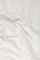 Le Coton Indien Tissé 001 ecru fabric draped in soft folds, revealing the raised woven floral pattern against the light.