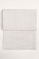 Le Coton Indien Tissé 001 ecru fabric, folded flat, with the tone-on-tone woven floral pattern visible across the whole piece.