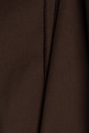Tissu gabardine légère marron chocolat suspendu en plis fluides et asymétriques, lisière visible sur le côté.