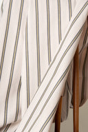 Tissu Weave Line écru à fines rayures gris-bleu et moutarde, drapé en plis obliques.