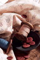 Gros plan sur l'imprimé pointillé graphique du tissu Vera rose poudré, marine et terracotta.