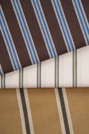 Éventail de trois tissus Weave Line pliés ensemble, rayures marron et bleu, écru et bleu-jaune, camel et taupe, présentés en famille de coloris.
